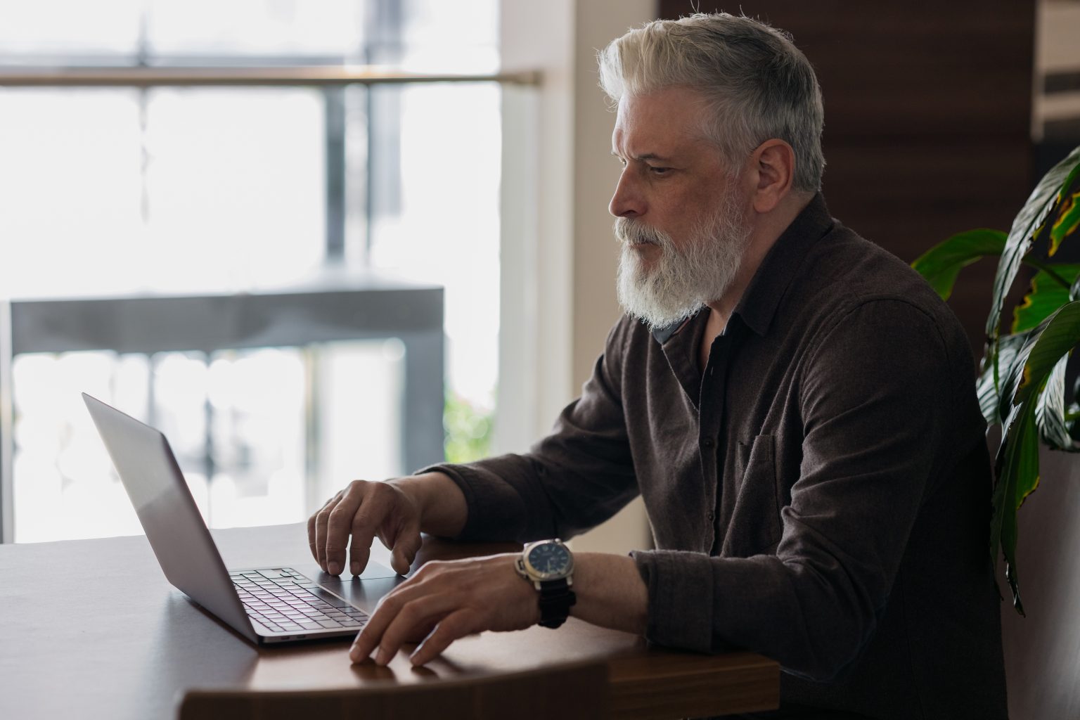 Retired man reviewing his Medicare plan options on a laptop at home